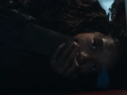 A girl hiding and covering her mouth so she won't make a noise