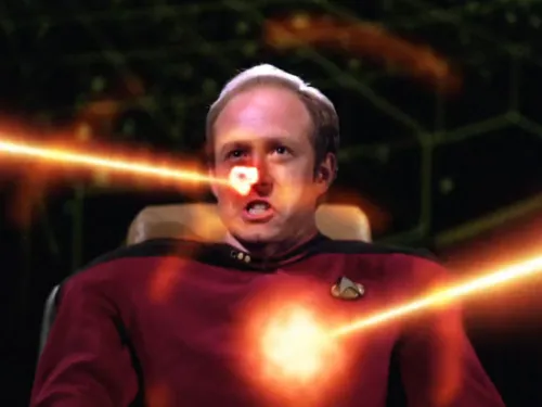 Two phaser beams striking Remmick's face and torso