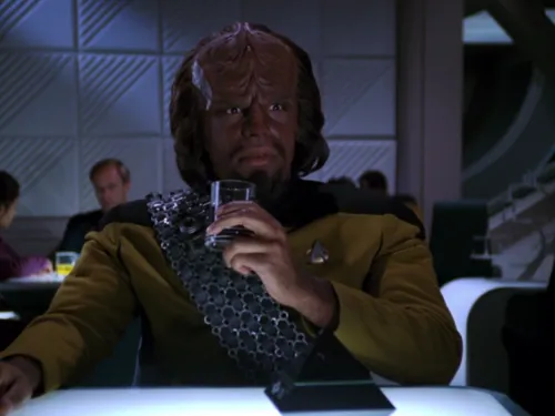 Worf holding a beverage in Ten Forward