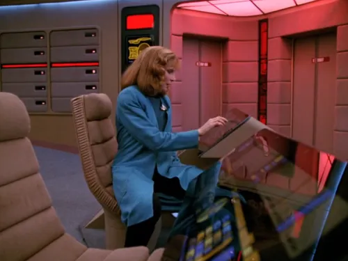 Crusher tapping at the ops console, alone on the bridge at red alert