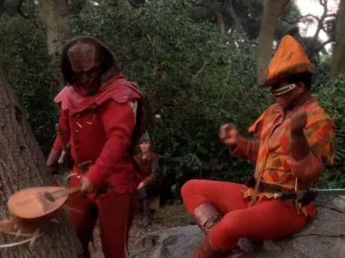 Worf, in tights, smashing a lute against a tree as La Forge, also in tights, recoils from the impact