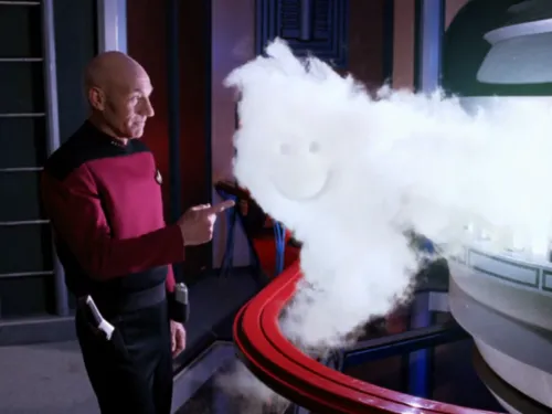 Picard pointing at a smiley face he has drawn in a cloud being emitted from the warp core