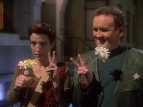 Kira and O'Brien holding flowers and making peace signs with their fingers