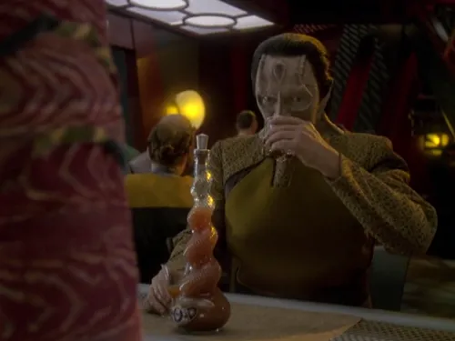 Garak sipping a glass of root beer while Quark awaits his reaction