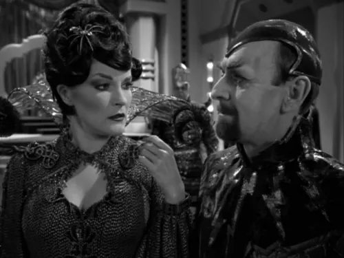 Janeway dressed as Arachnia, speaking with Dr. Chaotica in a black-and-white laboratory