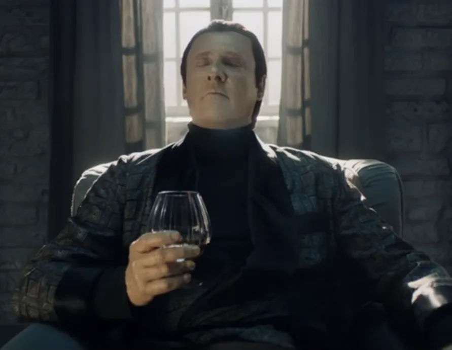 Data, with his eyes closed, in a smoking jacket holding a snifter with a dark beverage