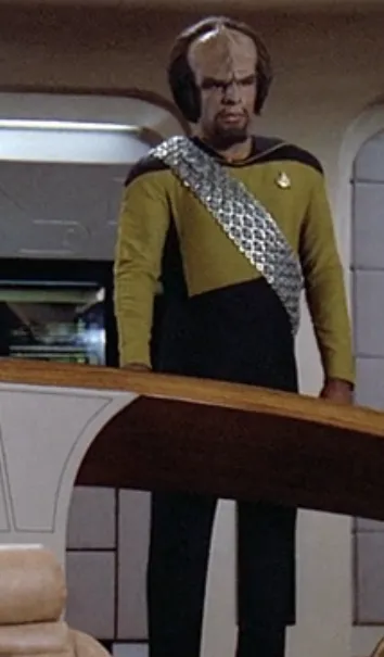 Worf, in a gold-colored Starfleet uniform on the bridge of the Enterprise-D