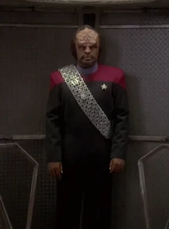 Worf in a new, red-colored uniform arriving in a turbolift at ops