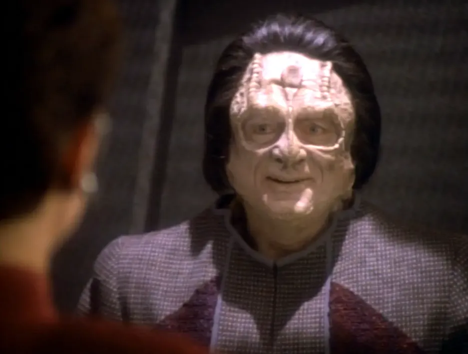 A Cardassian smiling at Kira from inside his holding cell