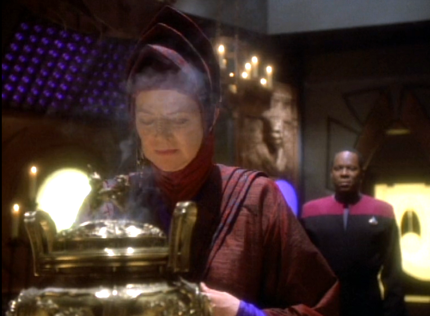 Vedek Winn praying over incense as Sisko observes from behind