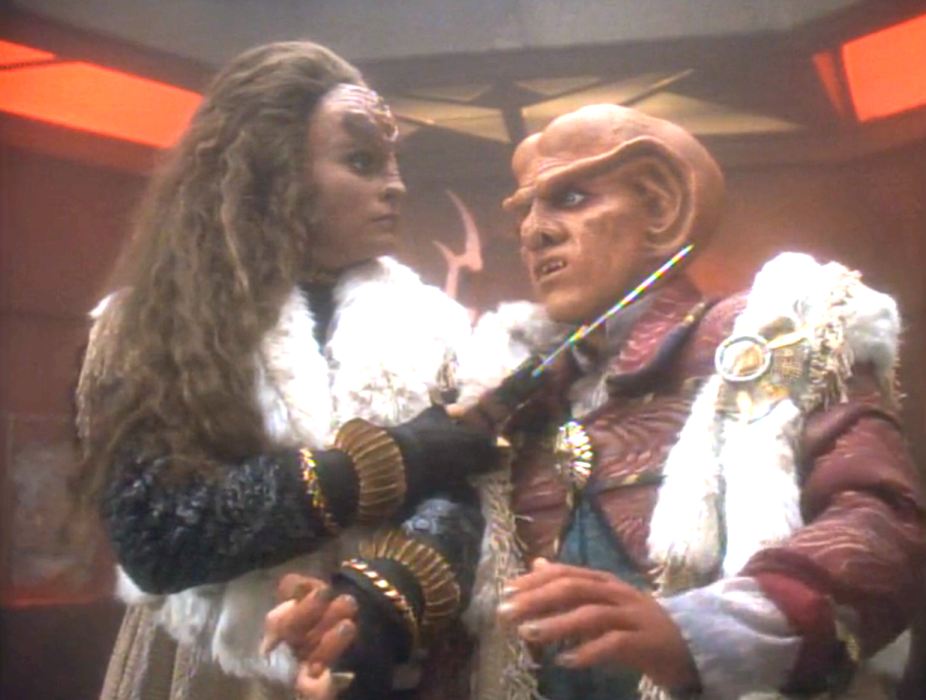 A Klingon holding a knife to Quark's throat