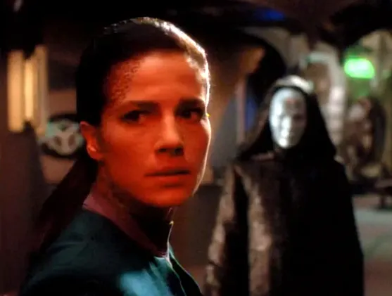 Dax standing with a hooded and masked figure on the Promenade