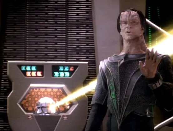 Dukat standing calmly in Ops while a weapon fires from the replicator
