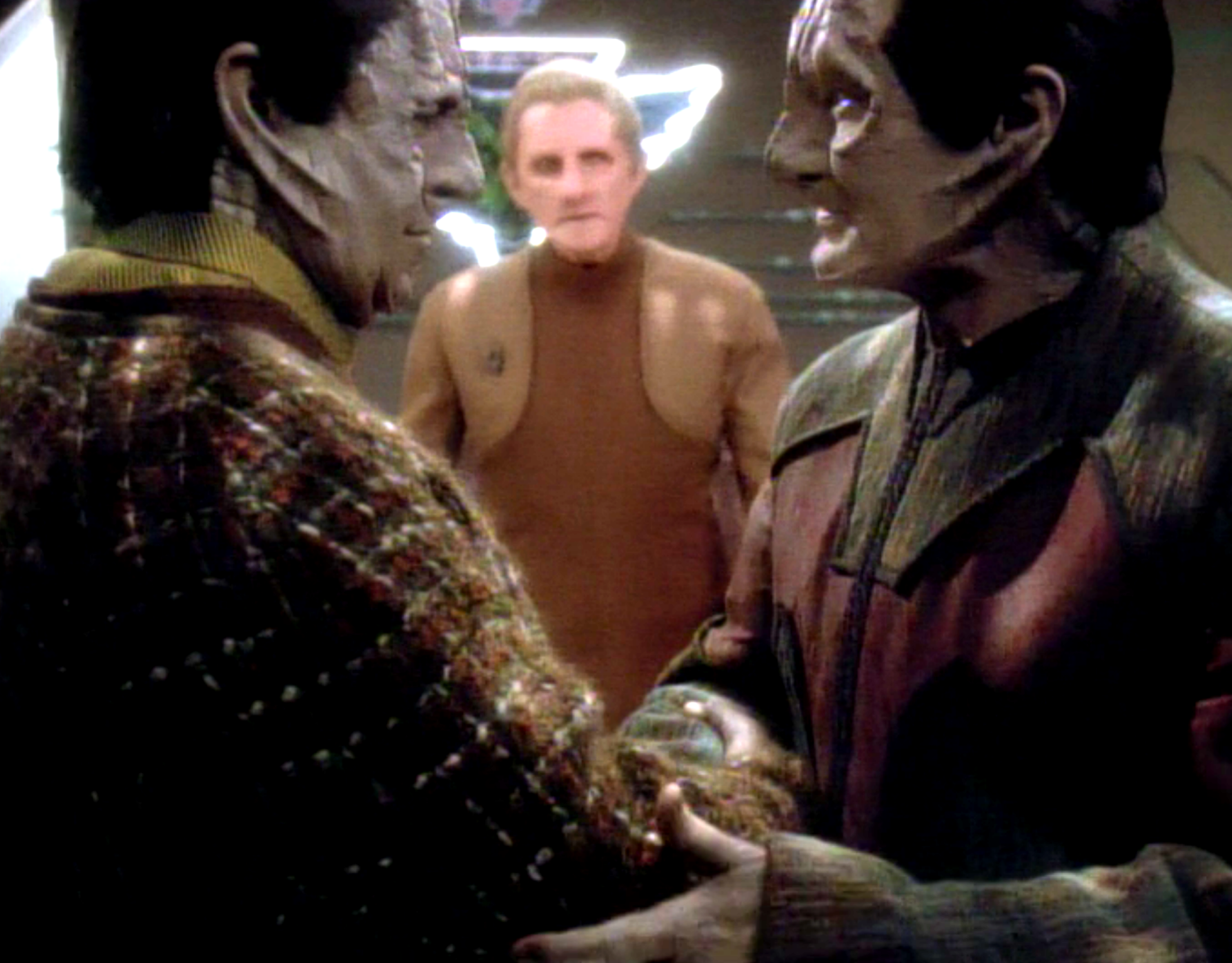 Garak and Enabran Tain shaking hands while Odo watches