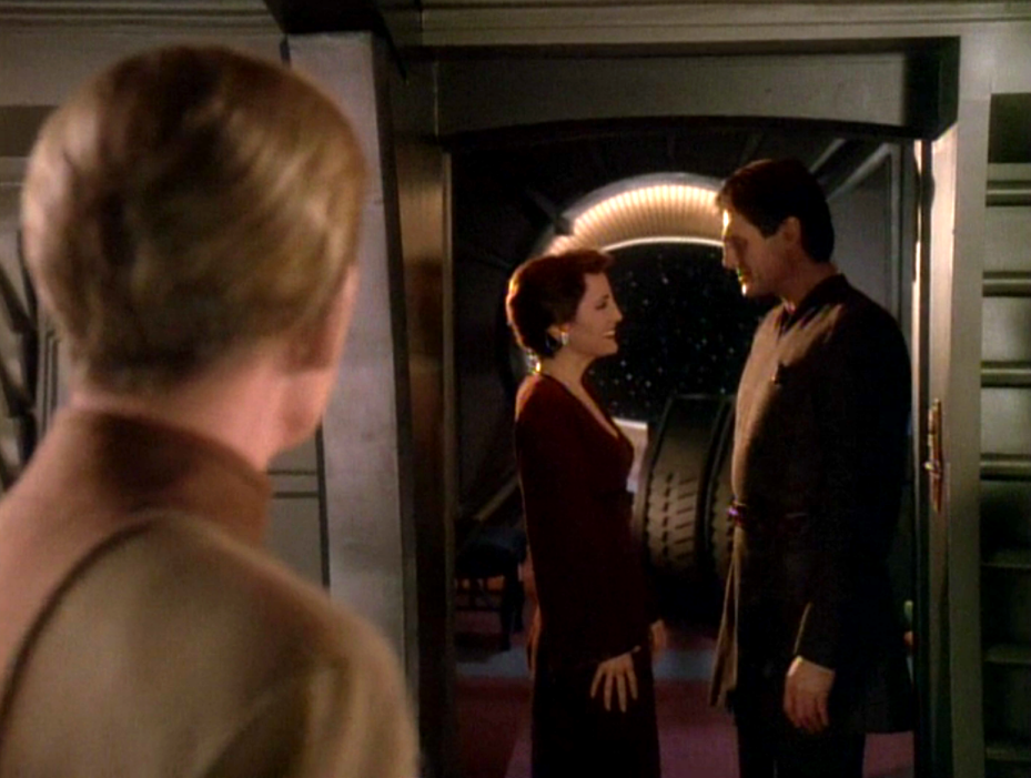 Kira and Shakaar talking and smiling while Odo watches