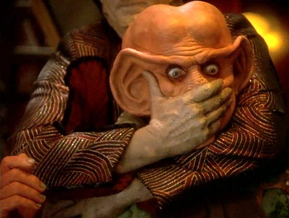 Somebody grabbing Quark and covering his mouth from behind