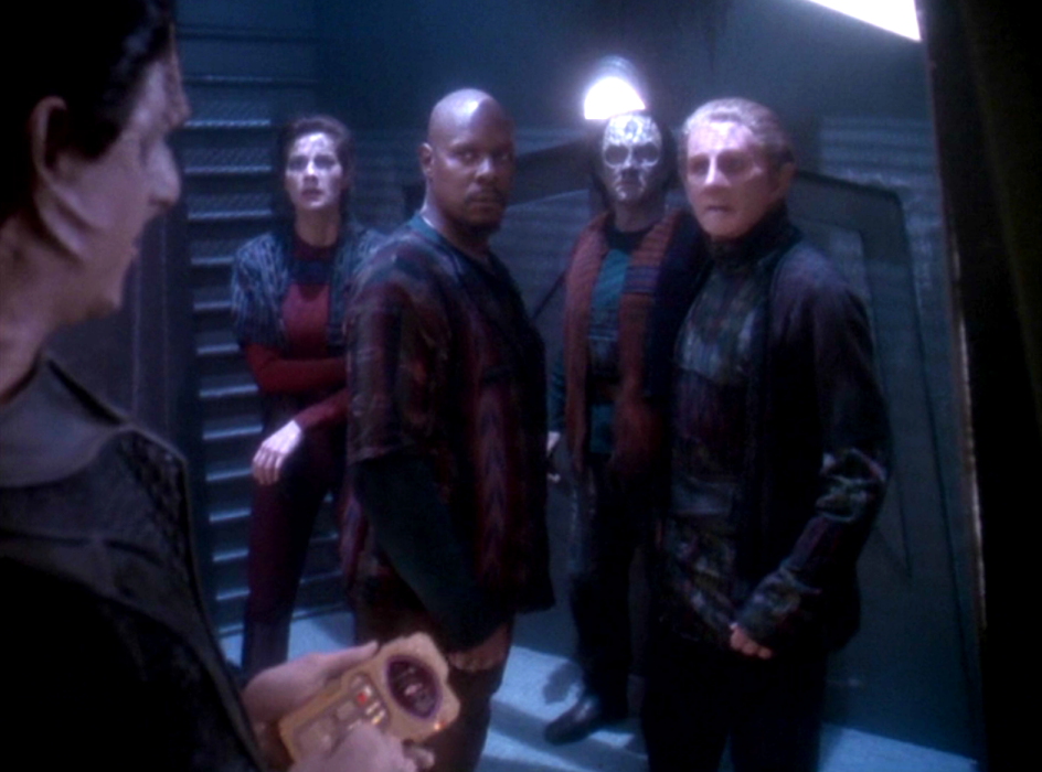 Dax, Sisko, Garak, and Odo in a holding cell wearing civilian clothing