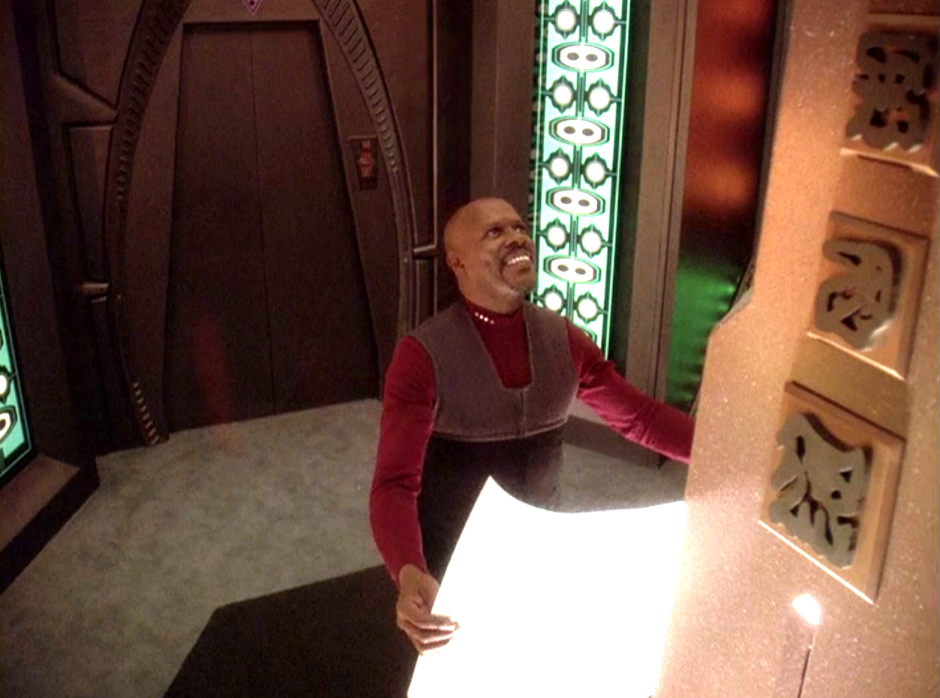 Sisko looking up and smiling at a Bajoran spire