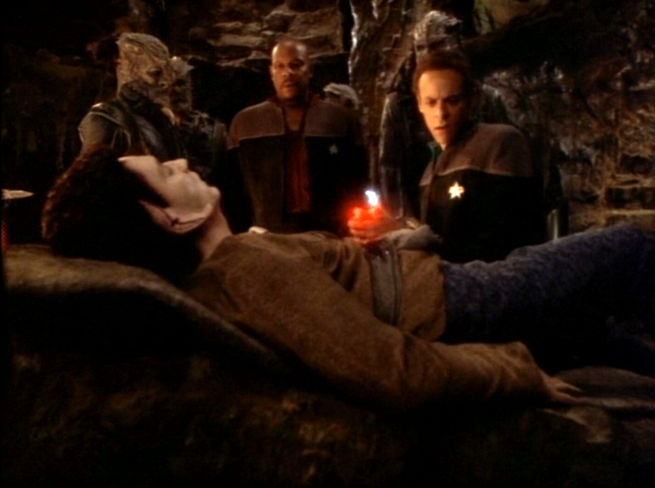 Sisko, Bashir, and several Jem'Hadar looking over an injured Vorta