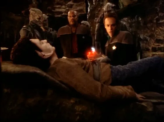 Sisko, Bashir, and several Jem'Hadar looking over an injured Vorta