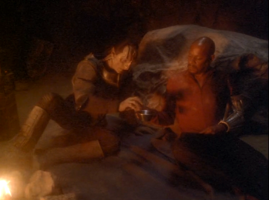 Dukat and Sisko sharing a meal in a cave