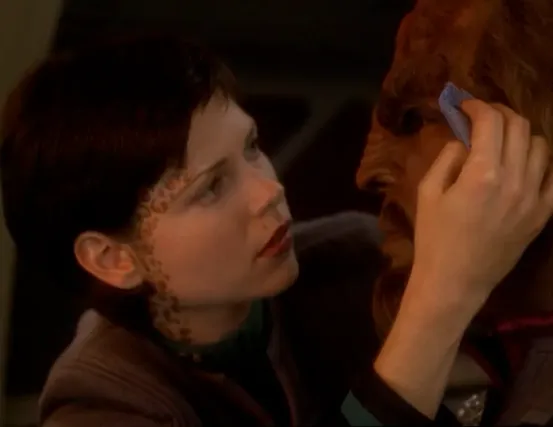 Ezri tending to a wound on Worf's face