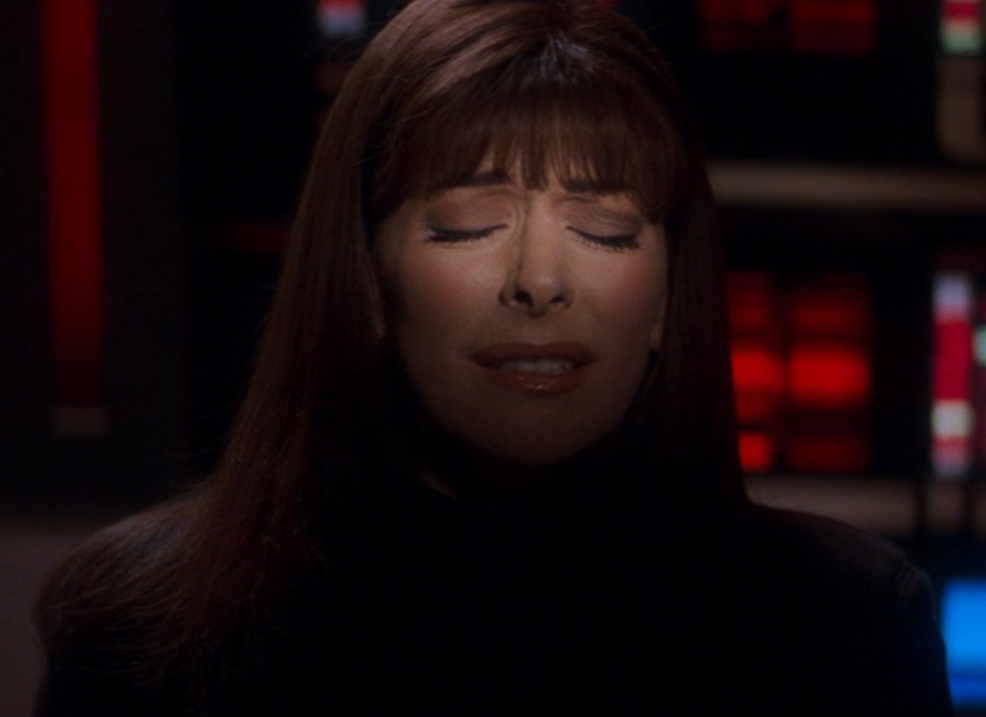 A picture of Deanna Troi concentrating, with her eyes closed, in a darkened room with only one band of light across her eyes