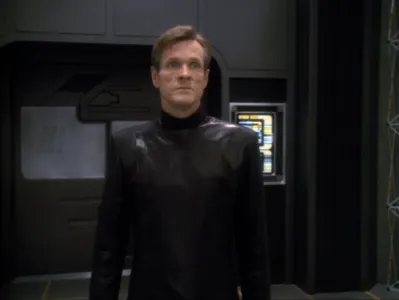 Luther Sloan wearing all black and looking serious 