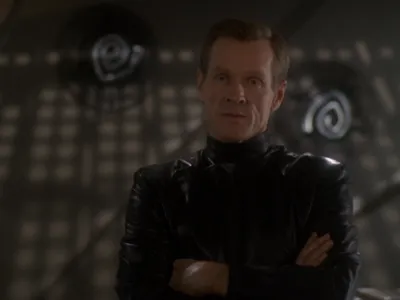 Luther Sloan with arms crossed, looking impatient 