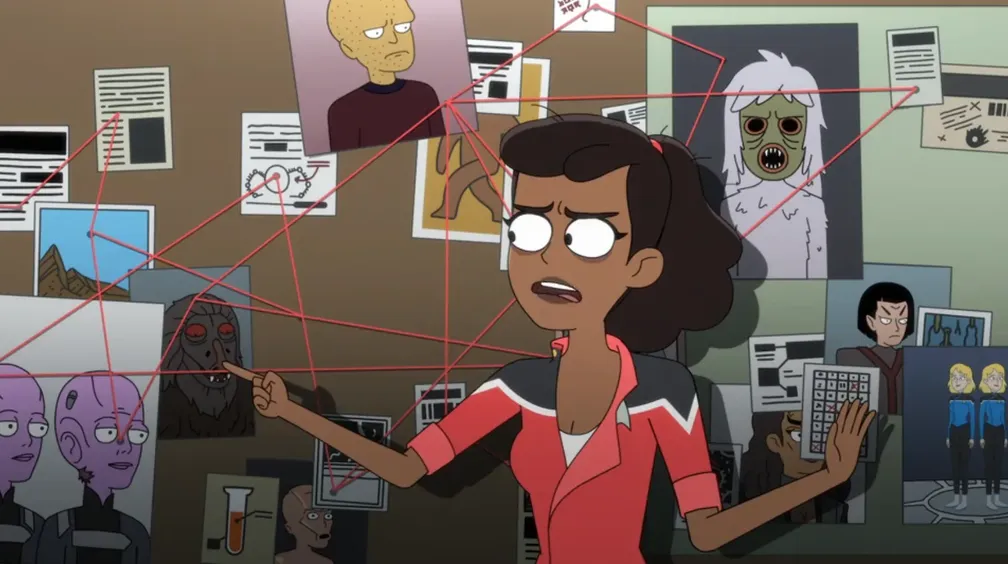 Mariner standing in front of a bulletin board covered in photos and articles all connected together with pinned red string