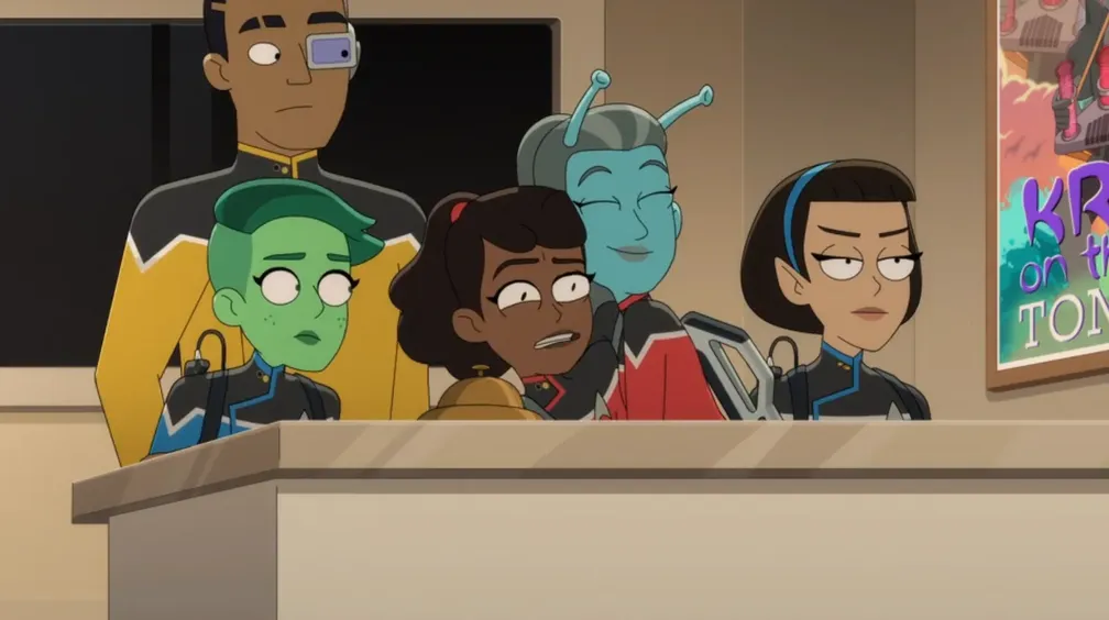 The lower-deckers hiding behind a desk while Jennifer hugs an uncomfortable-looking Mariner