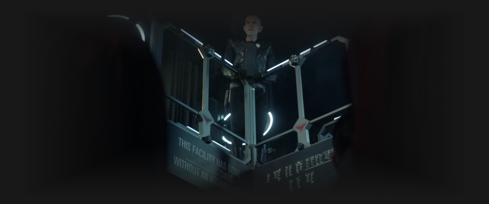 A Romulan speaking to a crowd from a balcony on the Borg cube