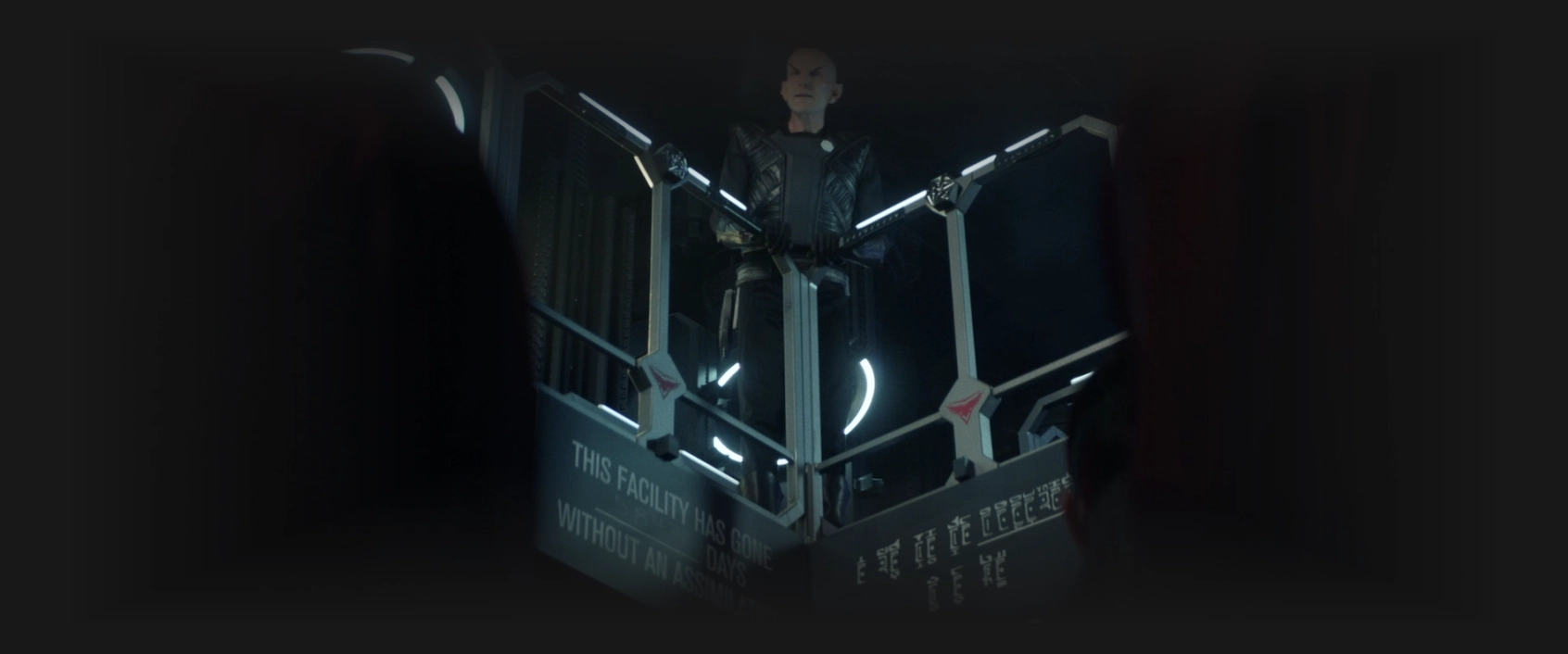 A Romulan speaking to a crowd from a balcony on the Borg cube