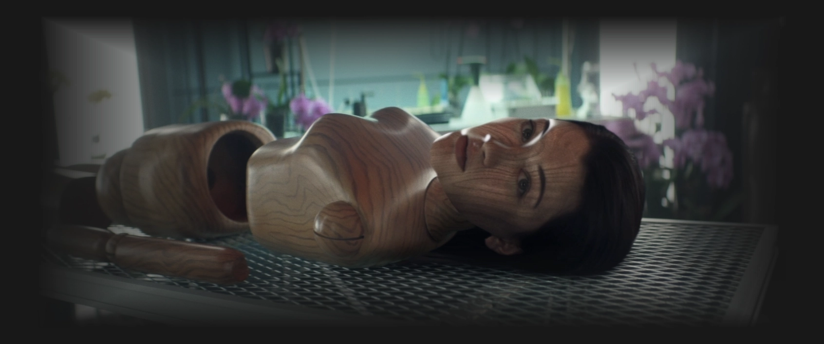 parts of a human-sized wooden doll lying on a table with Soji's face