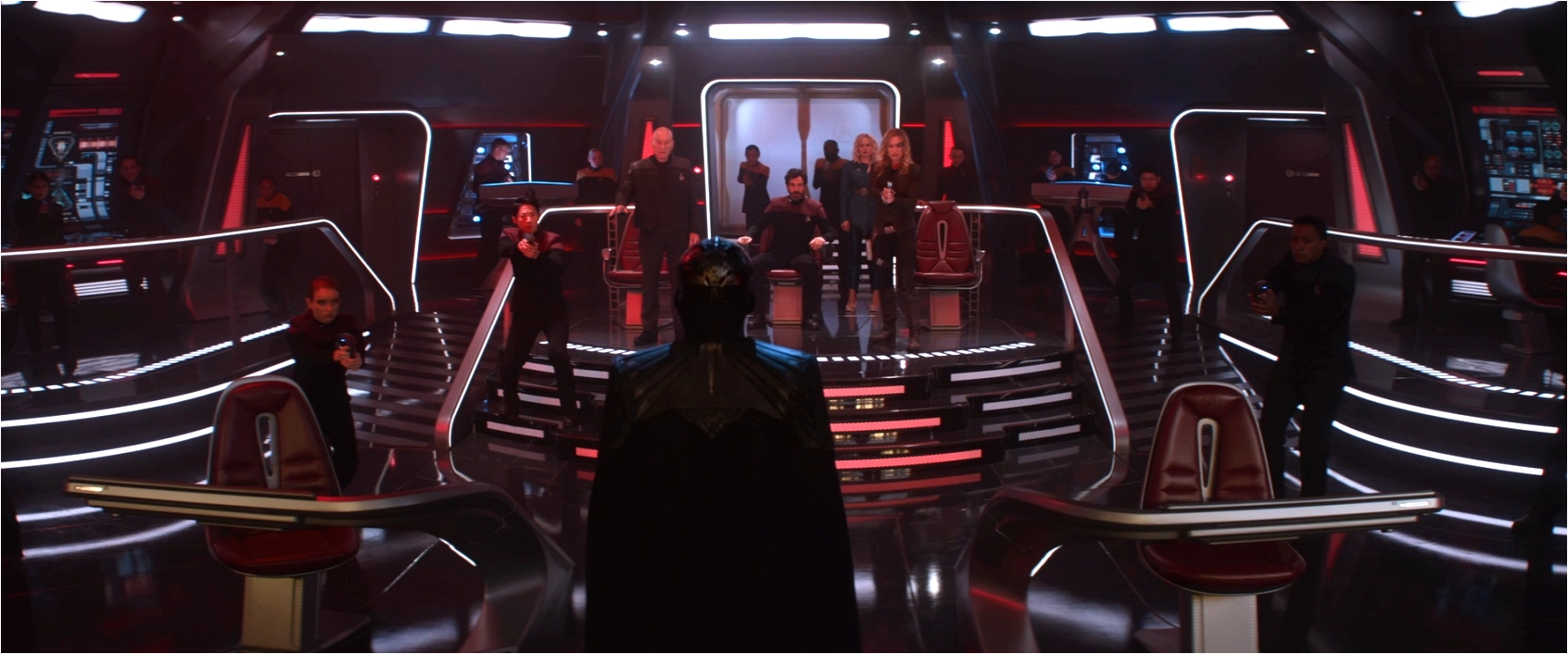 Picard, Rios, Jurati, and Seven on the bridge of a starship, with an ominous black-cloaked figure standing before them, and a dozen Starfleet officers pointing weapons at the figure