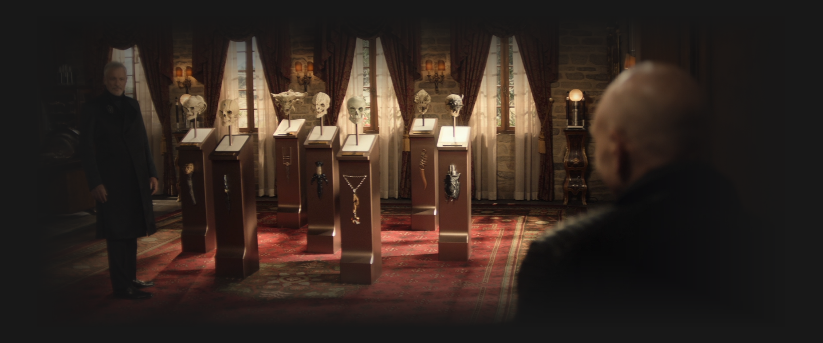 Q showing Picard seven pedestals, each with a skull on it