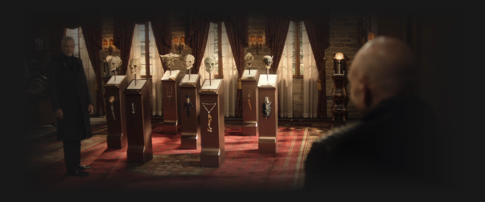 Q showing Picard seven pedestals, each with a skull on it