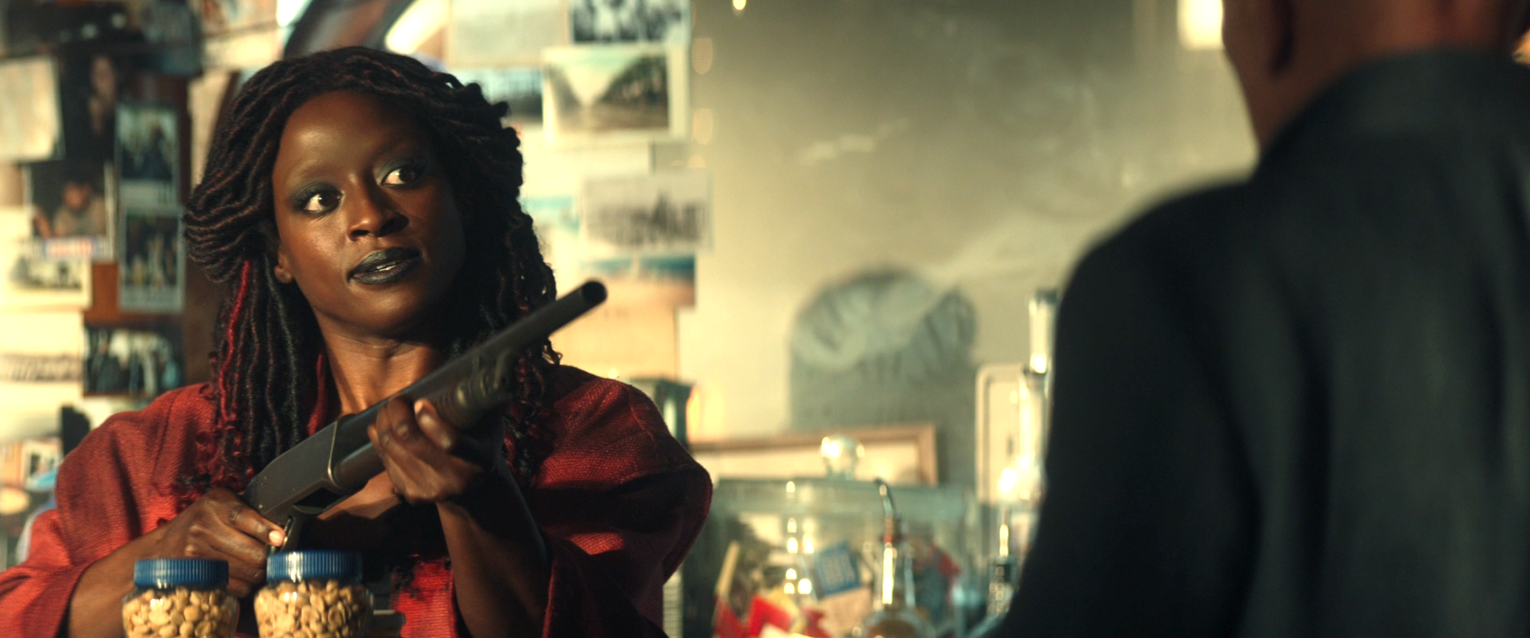 A young Guinan pointing a shotgun at Picard