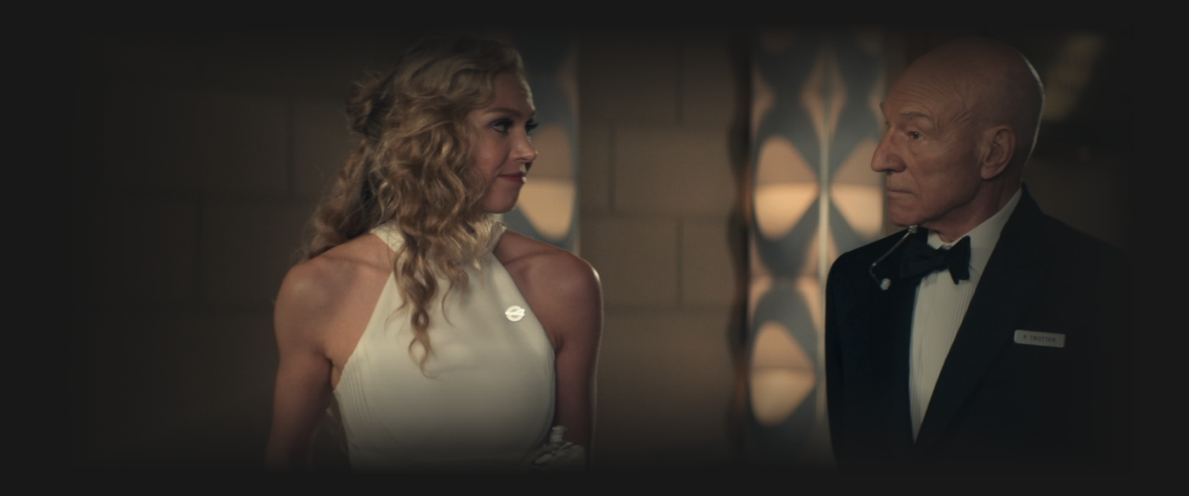 Picard, in a tuxedo, having a conversation with Renée Picard