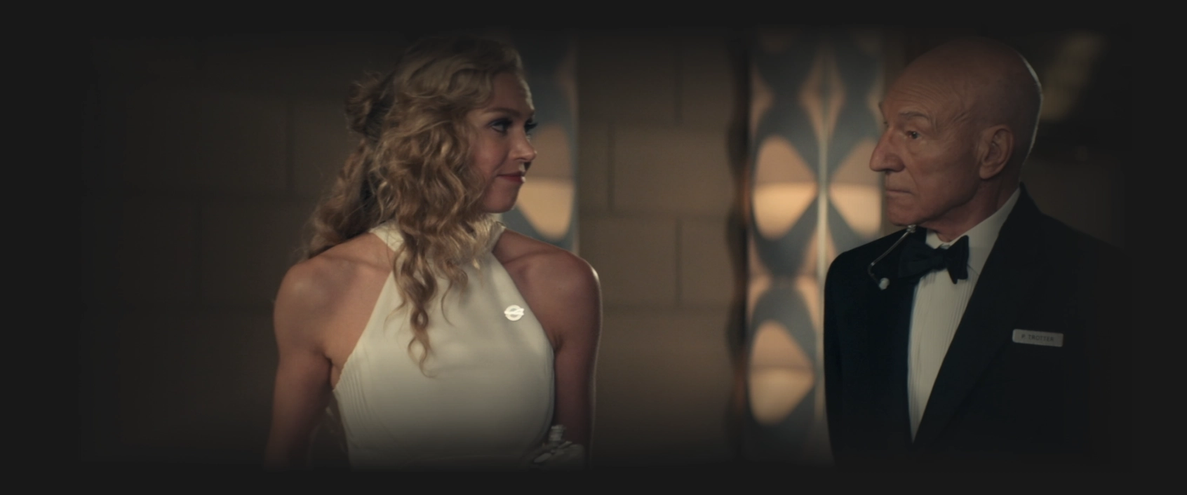 Picard, in a tuxedo, having a conversation with Renée Picard