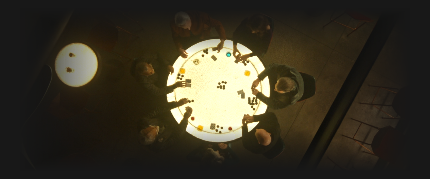 a birds-eye view of Crusher, Worf, La Forge, Riker, Picard, Troi, and Data, playing poker around a circular table