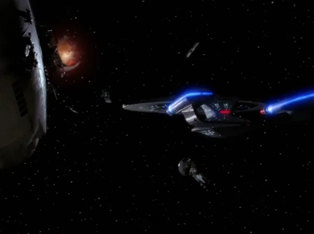 The Enterprise flying through a graveyard of destroyed Starfleet ships, still burning in space