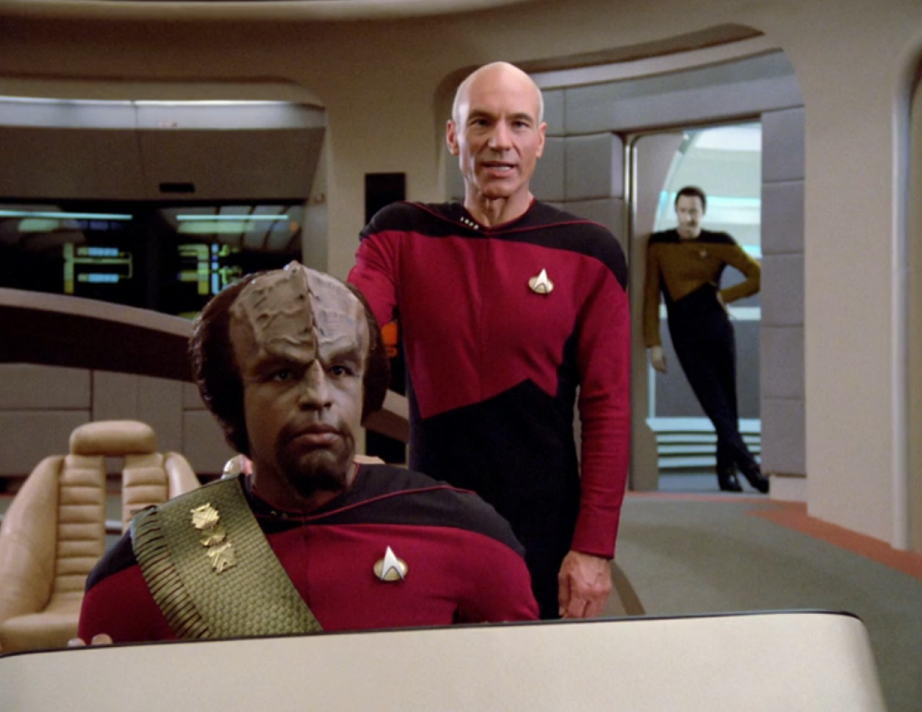 Picard and Worf on the bridge, with Data leaning casually on the wall of the turbolift that has just arrived