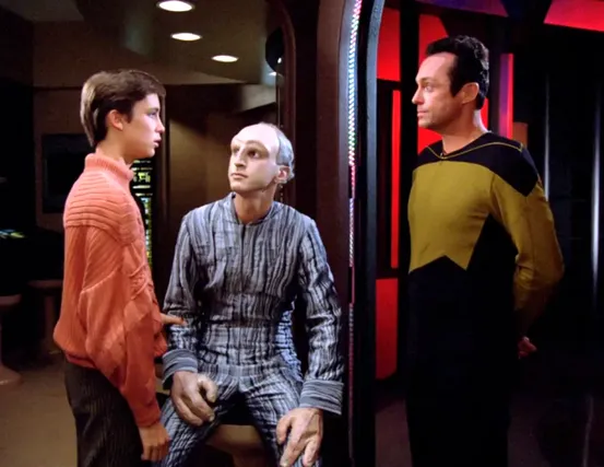 Wesley speaking with Kosinski and his alien assistant