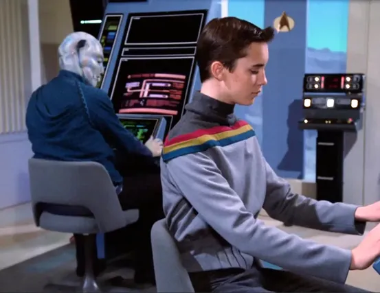 Wesley sitting at a computer terminal taking an exam for Starfleet Academy