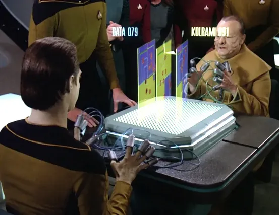 Data and Kolrami playing a tabletop electronic game