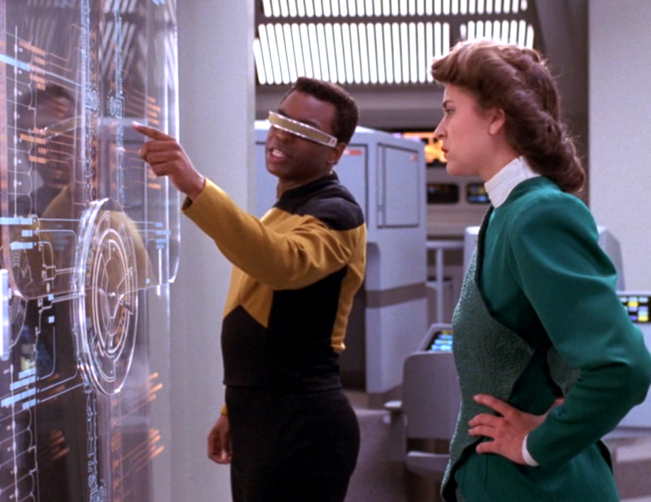 Geordi La Forge and a holographic Leah Brahms discussing strategy over schematics of the Enterprise