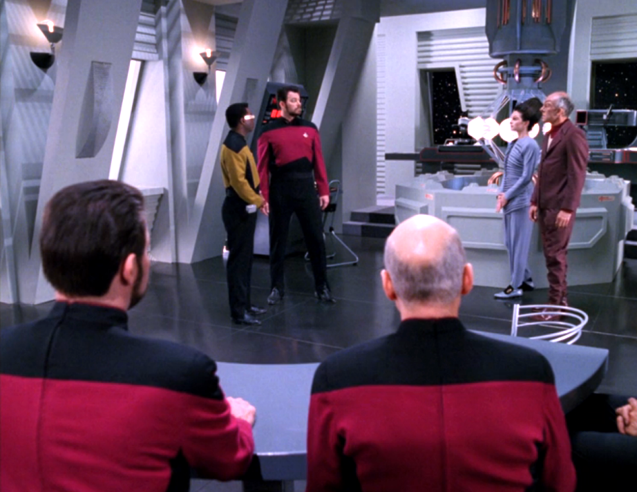 Riker and Picard observing a holographic re-creation of a conversation in the Krieger wave lab