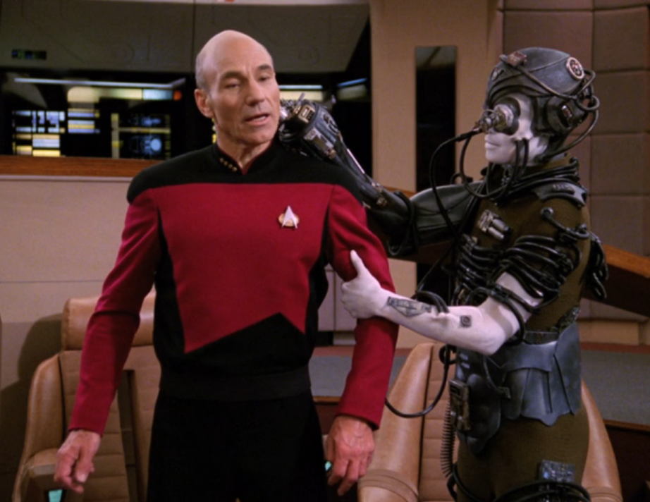 Picard being held and sedated by a Borg drone on the bridge of the Enterprise