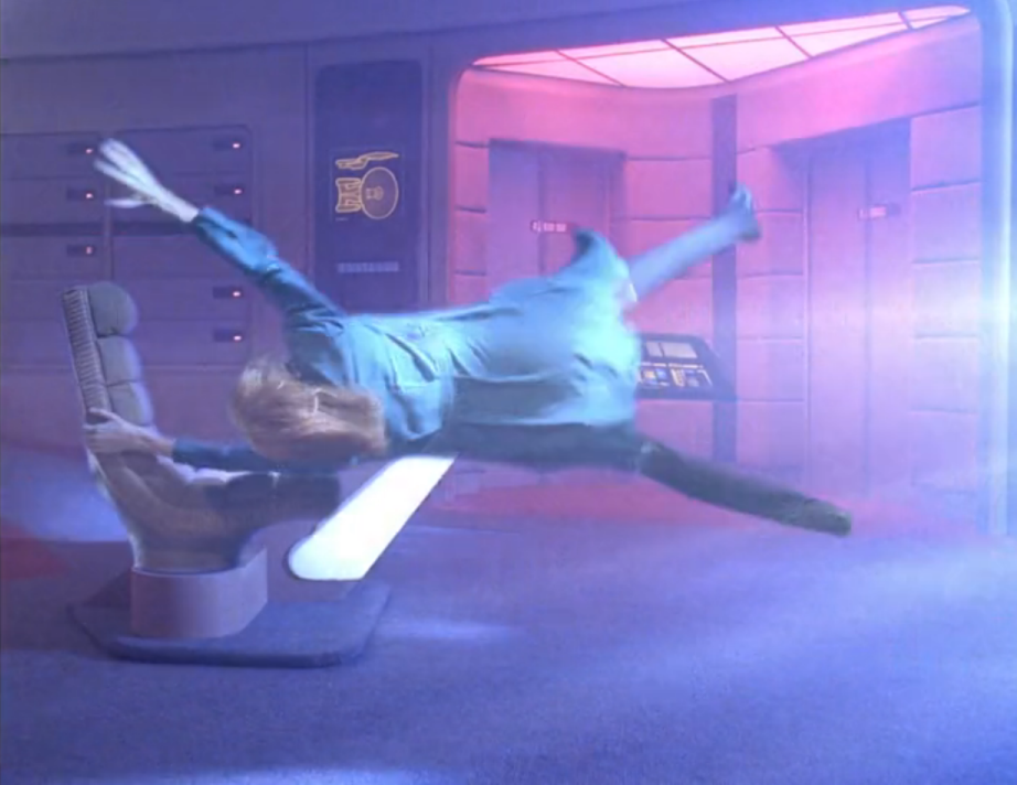 Dr. Crusher hanging on desperately as she is lifted horizontally by a powerful vortex